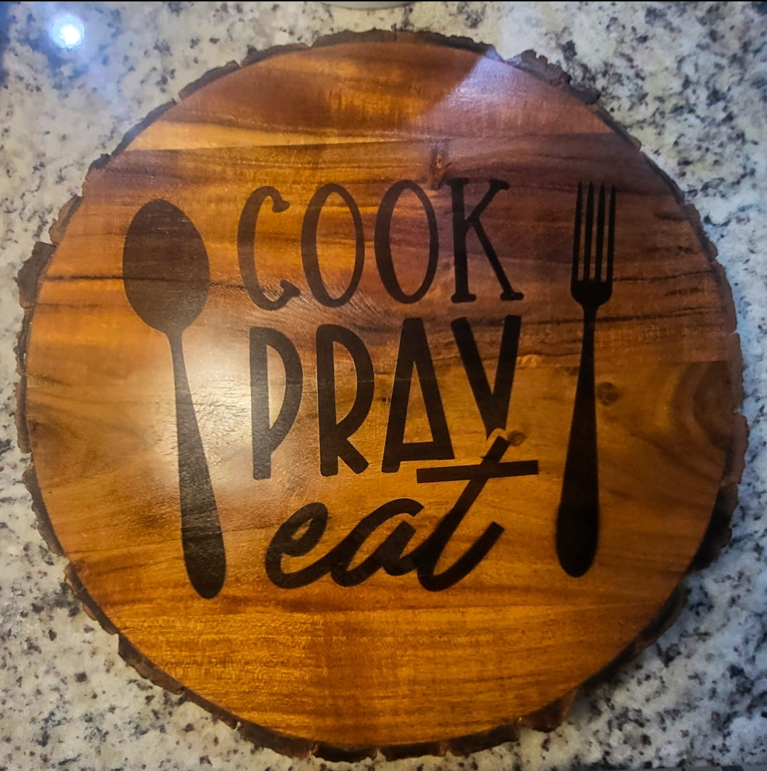 This 14-inch round wooden board comes with legs and is beautifully engraved with the words "COOK, PRAY, EAT."     Care instructions:  Hand Wash thoroughly before and after use.  Avoid abrasive cleaners.  Do not use over open flame.  Avoid cross-contamination of all food prep equipment.  Do not soak in water or exposed to heat or sunlight.  Wash with running water and dry after use.